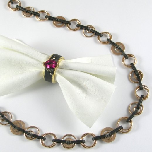 Ring aus Gelbgold und Carbon mit einem Rubelith. Collier aus Roségold und Carbon